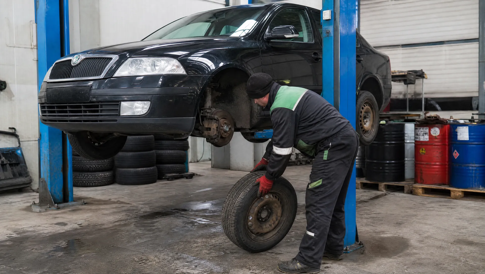 Likvidace vozidel Telnice – ilustrační foto: technik sundává kola z černé Škody Octavia na zvedáku